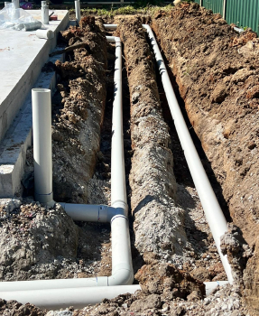 Underground drainage pipework installed alongside a building